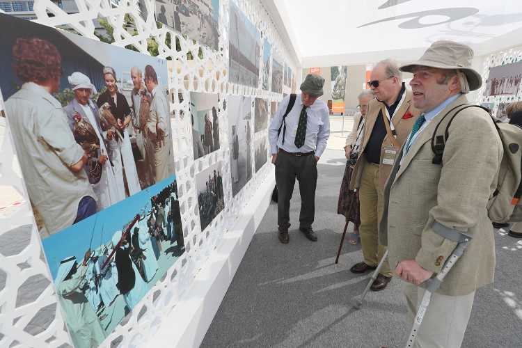 Robert Kenward and other veterans view their pictures from 1976