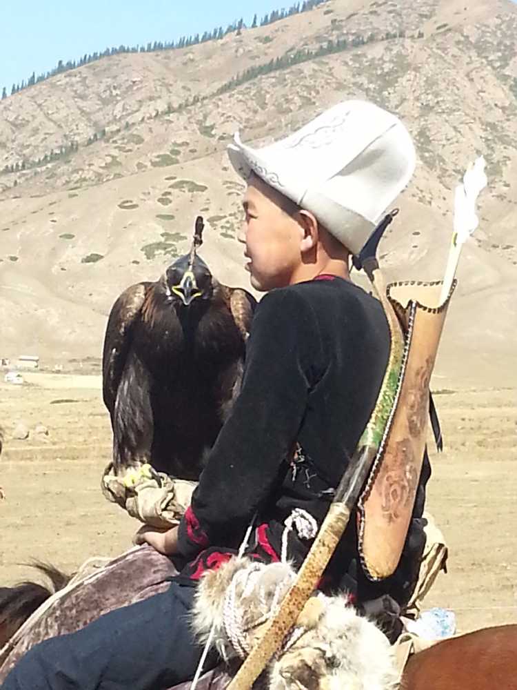 A young Kyrgyz falconer, on his horse for travelling the steppes.