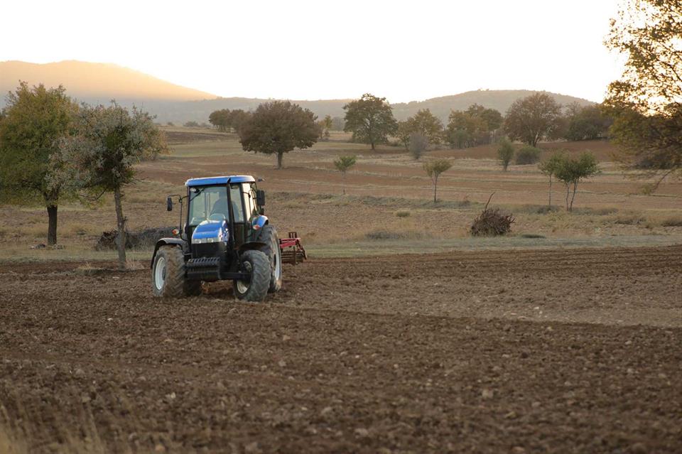 Descripción: Un tractor cultivando tierras agrícolas